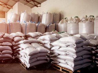 Bulk bags and palletised sacks of raw materials stored in an industrial warehouse